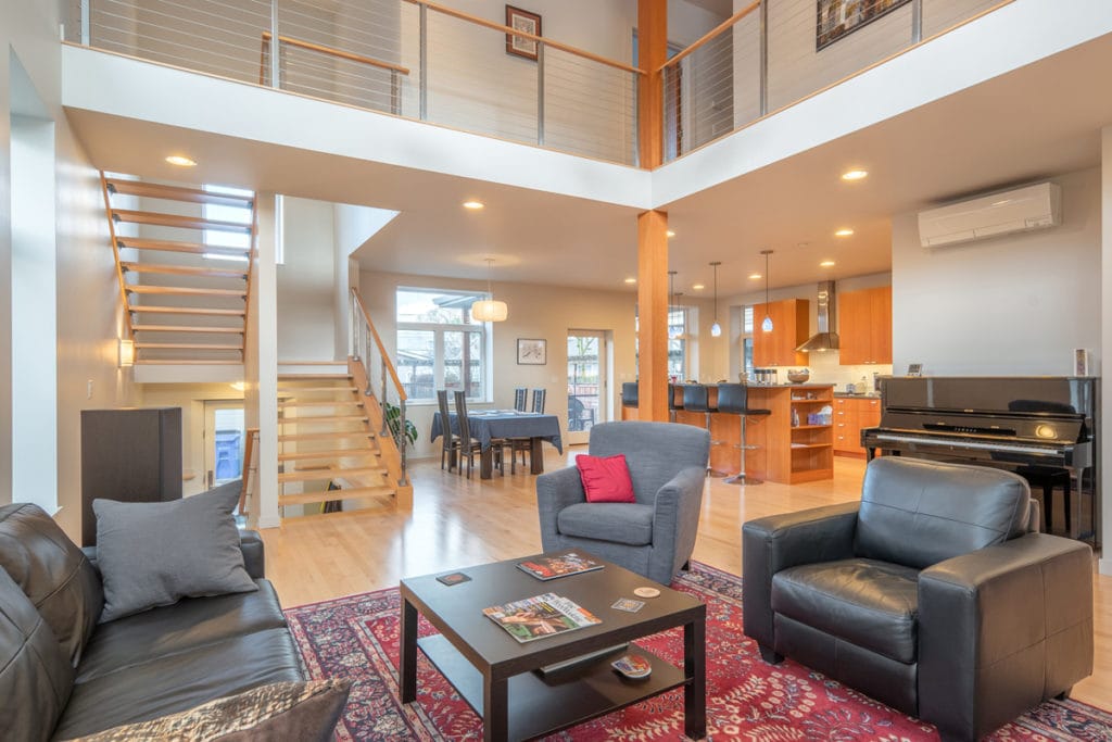 Modern open-concept living room with loft and open staircase — real estate & architectural photography by Wasim Muklashy, Portland OR
