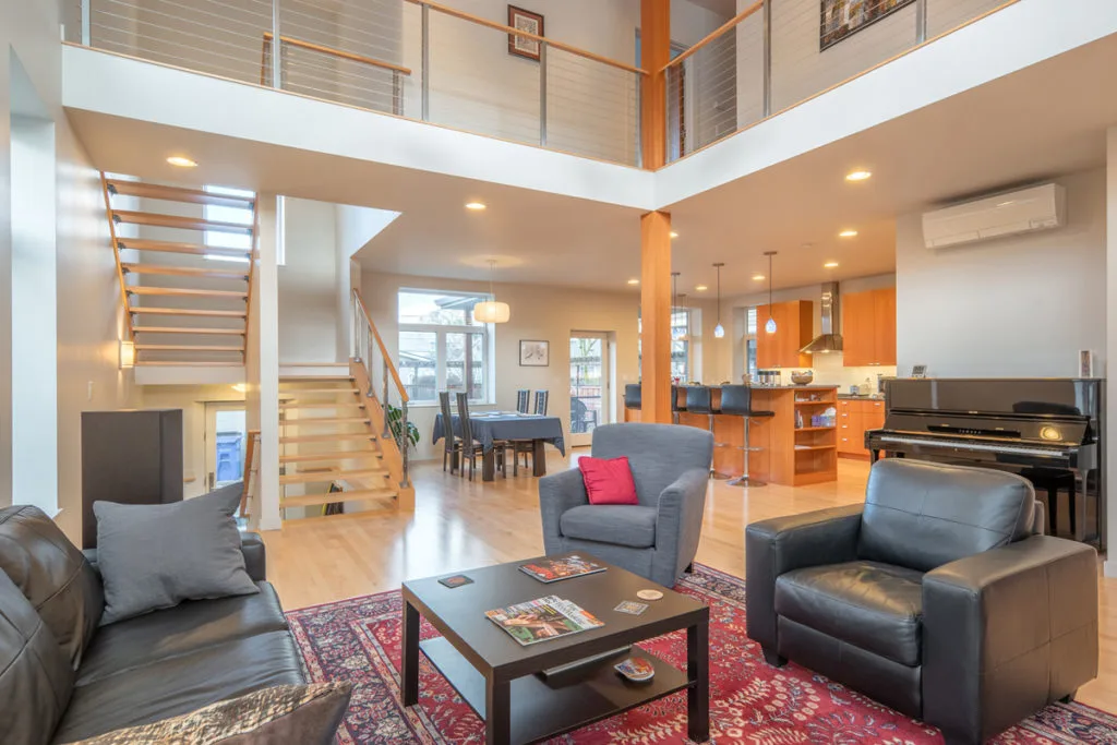 Modern open-concept living room with loft and open staircase — real estate & architectural photography by Wasim Muklashy, Portland OR